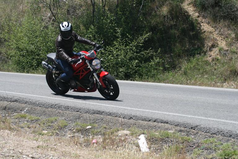 Motorkár jazdí po ceste, červeno-čierna motorka